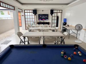 a pool table in a room with tables and chairs at Casa Sakura 2 in Calamba