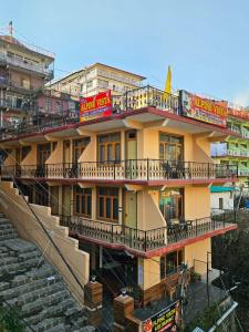 a building with balconies and stairs in a city at Hotel Alpine Vista formerly Green View Hotel and Restaurant in Dharmsāla