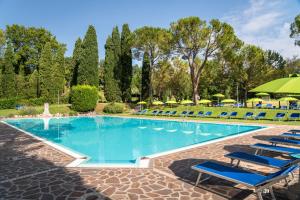 a swimming pool with lounge chairs and an umbrella at West Garda Hotel in Padenghe sul Garda