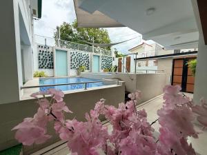 a balcony with pink flowers and a swimming pool at Casa Sakura 2 in Calamba