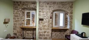 a room with two windows on a stone wall at Palazzo Gabela in Risan