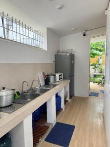 a kitchen with a sink and a refrigerator at Casa Sakura 2 in Calamba