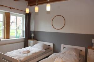 a bedroom with two beds and a mirror on the wall at Ferienwohnung Hof Alms in Uelzen