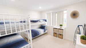 a bedroom with two bunk beds and a window at Sandy Feet in Wooli +5 photos