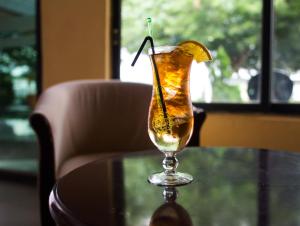 a drink on a glass table with a lemon slice at Mika Lodge in Lusaka