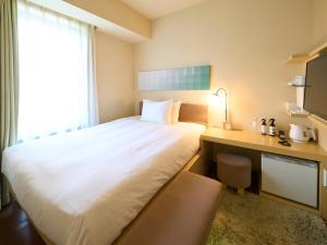 a hotel room with a large bed and a desk at Hotel Resol Ikebukuro in Tokyo