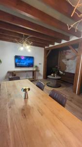 a dining room with a large wooden table and chairs at La Belle au Bois Joli in Raon-lʼÉtape