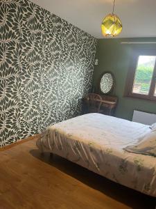 a bedroom with a bed and a patterned wall at La Belle au Bois Joli in Raon-lʼÉtape