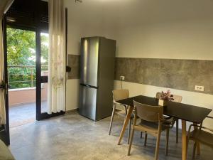 a kitchen with a table and a stainless steel refrigerator at ERA Vila 36 Durres in Durrës