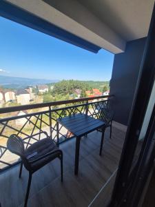a balcony with two chairs and a table and a view at Hill residence A 119 Boby in Cajetina