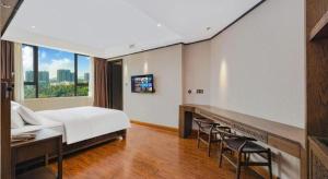 a bedroom with a bed and a desk and chairs at HELSTON HOTEL in Guancun