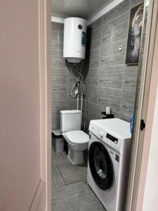 a bathroom with a toilet and a washing machine at The Barn in Cholpon-Ata +13 photos