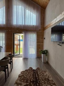 a living room with a table and a large window at The Barn in Cholpon-Ata