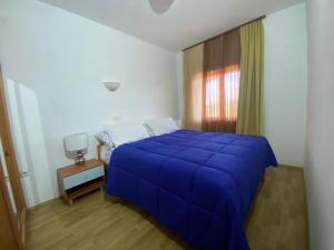 a bedroom with a blue bed and a window at Apartments Ava in Babići
