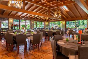 a dining room with tables and chairs and windows at West Garda Hotel in Padenghe sul Garda