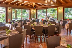 a dining room with tables and chairs and windows at West Garda Hotel in Padenghe sul Garda