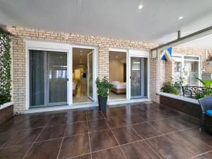 an outdoor patio with glass doors and plants at Lucia Hotel Paralia in Paralia Katerinis