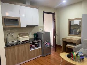 a kitchen with a sink and a refrigerator and a table at Flick Zone Trung Lực in Lực Hánh