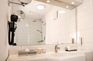 a bathroom with a sink and a mirror at Hotel Frisia in Leer +22 photos