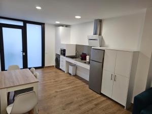a kitchen with white cabinets and a table with chairs at El Gabal in Soto de la Marina