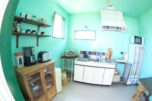 eine blaue Küche mit einer Spüle und einem Kühlschrank in der Unterkunft PavilionSurf&Lodge in Shishikui