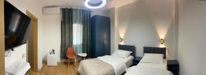 a bedroom with two beds and a tv and a window at ERA Vila 36 Durres in Durrës