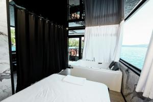 a bathroom with two beds and a tub and a window at Dream house in Rragam
