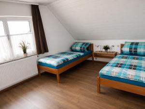 a bedroom with two beds and a window at BodenSEE Haus am Geissbock in Meckenbeuren