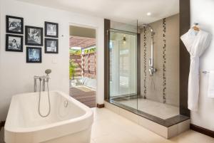 a bathroom with a white tub and a shower at Villa Karma by muse villas in Grand-Baie +7 photos