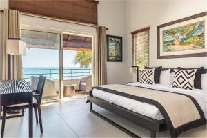 a bedroom with a bed and a view of the ocean at Villa Karma by muse villas in Grand-Baie