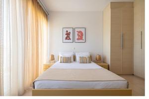 a bedroom with a large bed with two pillows at Beach Bar VIlla in Lefkada