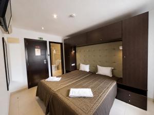 a bedroom with a bed with two towels on it at Residência São Francisco by Umbral in Fátima