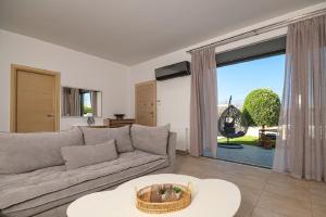 a living room with a couch and a large window at Beach Bar VIlla in Lefkada