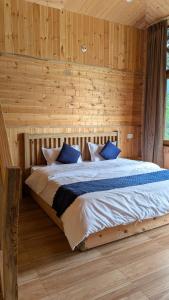 a bedroom with a large bed in a wooden wall at The Himalayan Monarch in Chakrāta