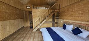 a room with a bed with a staircase in it at The Himalayan Monarch in Chakrāta