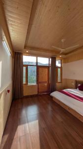 a large bedroom with a bed and a large window at The Himalayan Monarch in Chakrāta