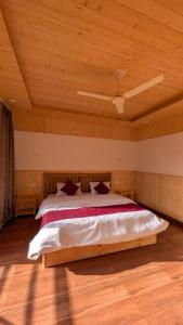 a bed in a room with a wooden ceiling at The Himalayan Monarch in Chakrāta +4 photos