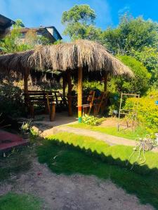 a hut with a table and a straw roof at Sana's homestay haputhale in Haputale