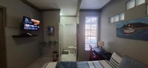 a bathroom with a bed and a toilet and a television at Middelbult Guesthouse by Heybert in Secunda