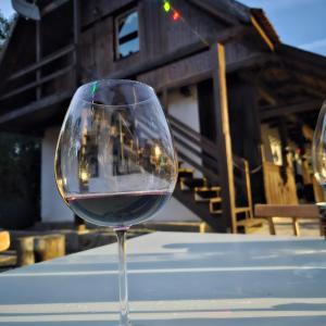 a glass of red wine sitting on a table at Pensiunea Energy in Căpuşu Mic