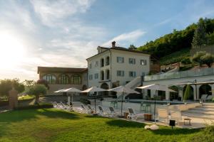 a building with a bunch of chairs and umbrellas at Vinea Relais in Dogliani