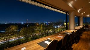 a long table with chairs and a view of the city at ホテルドゥアッシュ in Kushiro +69 photos