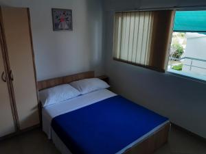 a small bedroom with a blue bed with a window at Apartman Jednosoban, Dvosoban, Trosoban in Sukošan