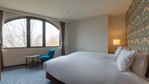 a hotel room with a large bed and a window at ホテルドゥアッシュ in Kushiro