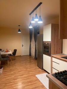 a kitchen with a refrigerator and a table with a dining room at Confort Apartament in Floreşti