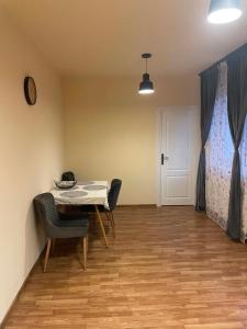 a dining room with a table and chairs and a bed at Confort Apartament in Floreşti