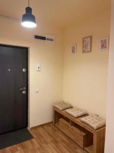 a room with two benches and a black door at Confort Apartament in Floreşti