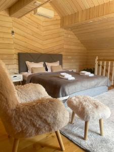 a bedroom with two beds and a chair in a room at InMonteHouse in Migovo