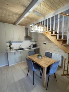 a kitchen with a wooden table and blue chairs at InMonteHouse in Migovo