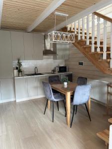 a kitchen with a wooden table and chairs and a staircase at InMonteHouse in Migovo +14 photos